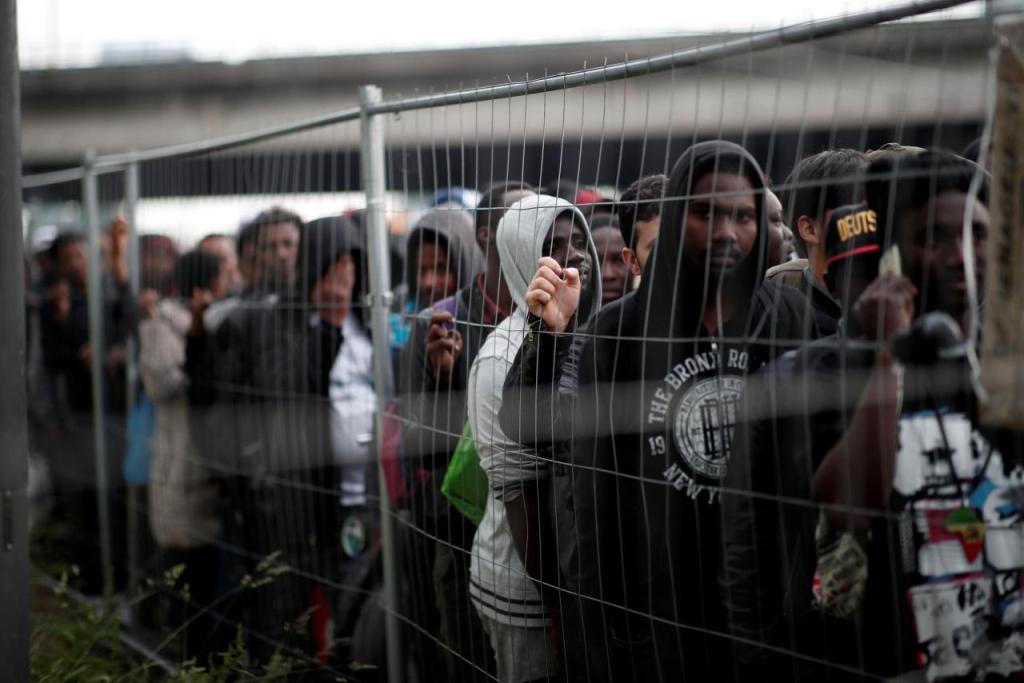 Migrants with their belongings stand in line as French police evacuate hundreds of migrants living in makeshift camps in Paris, France, May 30, 2018. REUTERS/Benoit Tessier