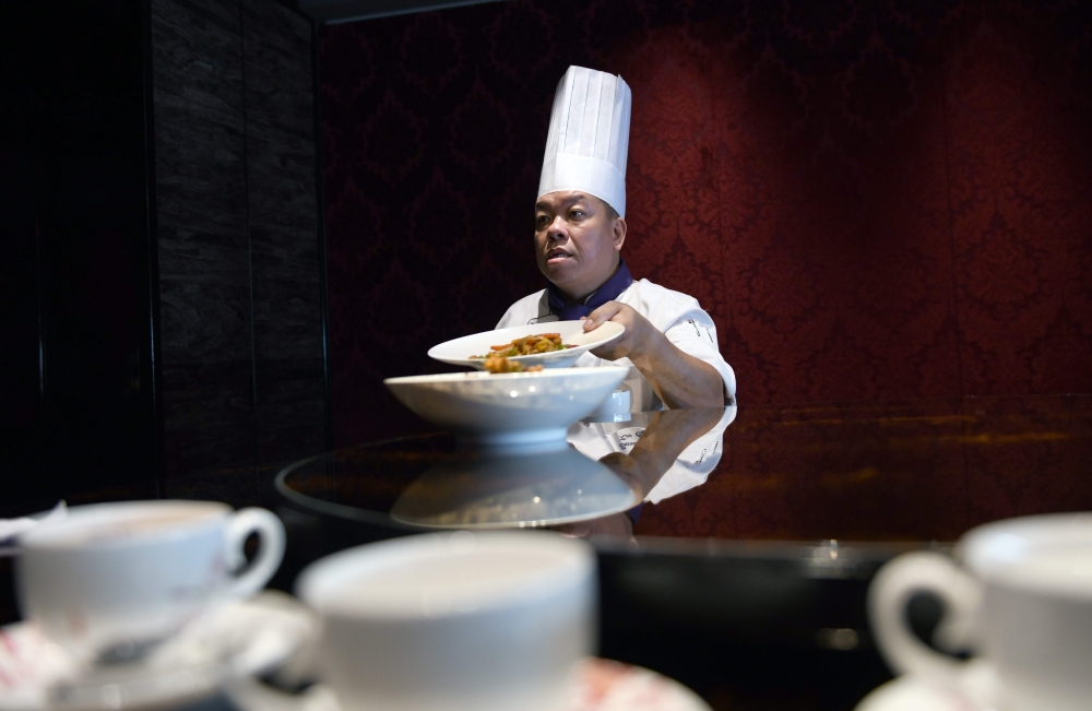 This picture taken on May 17, 2018 shows Ken Chan, the executive chef at the five-star hotel restaurant Le Palais in Taipei, displaying two dishes during an interview with AFP in Taipei. AFP / SAM YEH 
