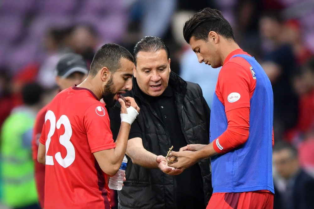 Tunisia's head coach Nabil Maaloul (C) distributes dates to Tunisia's midfielder Naim Sliti (L) and Tunisia's defender Rami Bedoui during the friendly football match between Tunisia and Turkey at the Stade de Geneve stadium in Geneva on June 1, 2018.  AFP