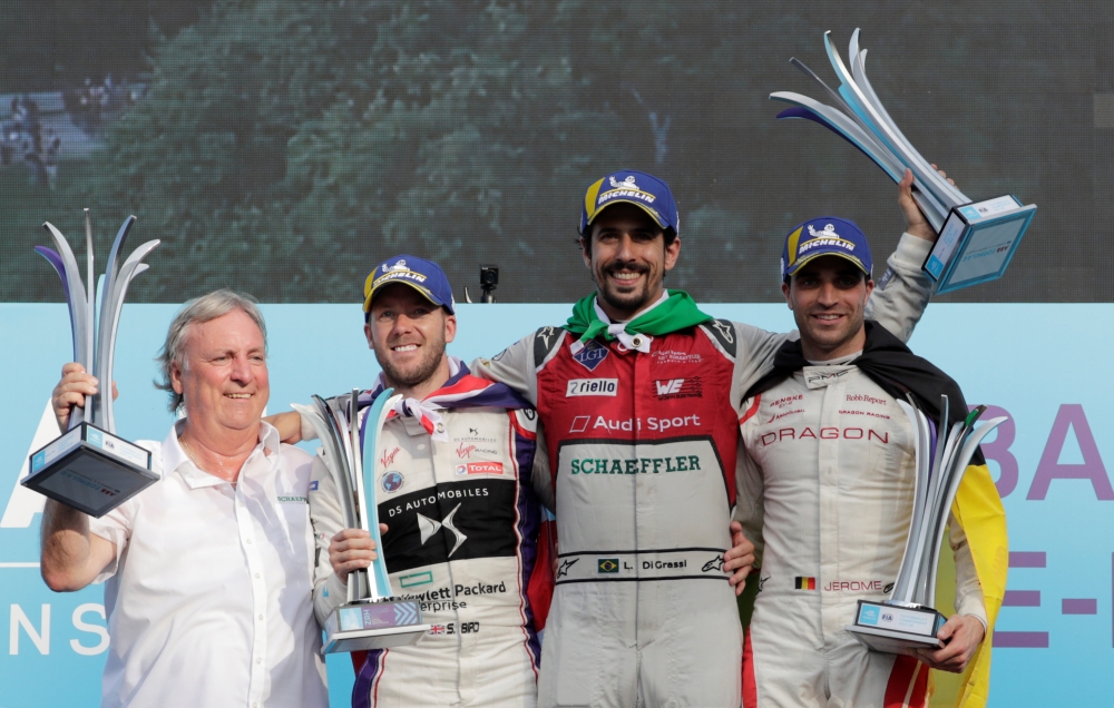 Audi Sport ABT Schaeffler's Lucas Di Grassi celebrates after winning the race with second-placed DS Virgin Racing's Sam Bird and third-placed Dragon's Jerome D'Ambrosio, next to Schaeffler Chief Technology Officer Peter Gutzmer, during the podium ceremony