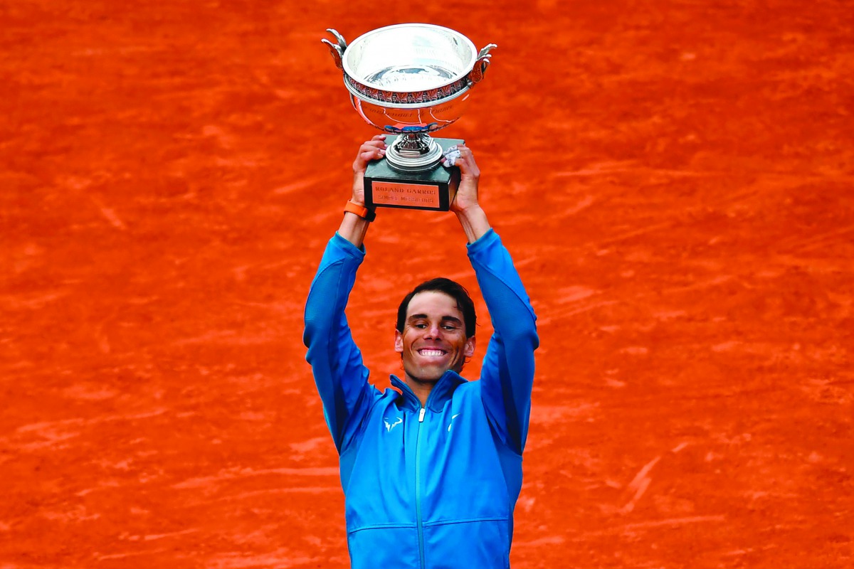 TOPSHOT - Spain's Rafael Nadal holds La Coupe des Mousquetaires - The Musketeers' Trophy after defeating Austria's Dominic Thiem in their men's singles final match on day fifteen of The Roland Garros 2018 French Open tennis tournament in Paris on June 10,