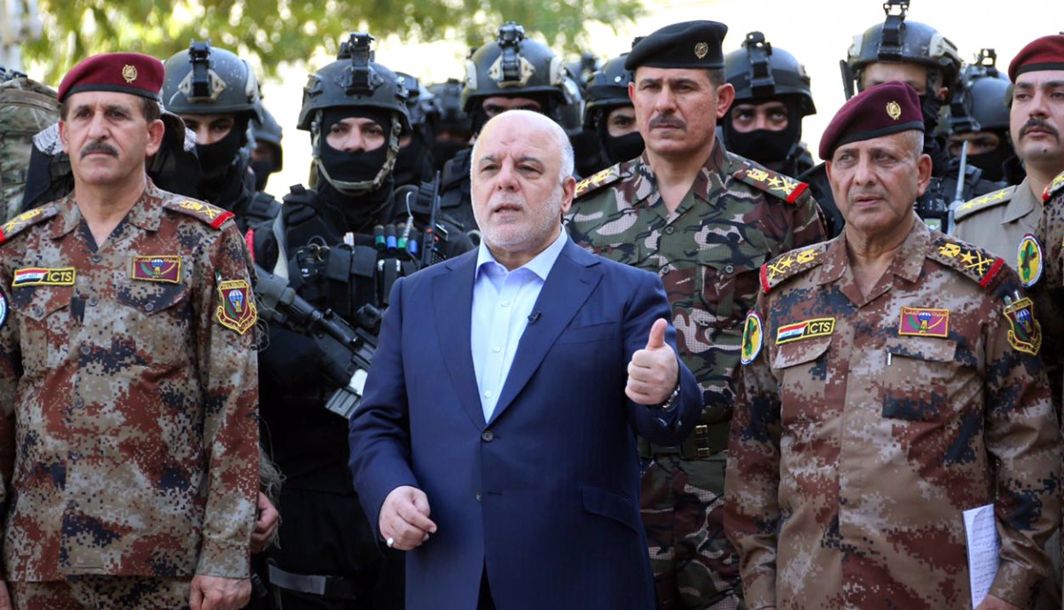 A handout picture released on July 9, 2016 shows Haider al-Abadi posing for a picture with army and counter-terrorism forces in the capital Baghdad (via AFP) 