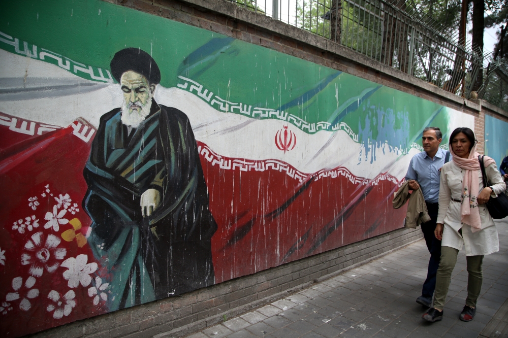 People past a mural painted on the wall of the former US Embassy in Tehran, Iran on May 9, 2018. (Fatemeh Bahrami / Anadolu Agency) 