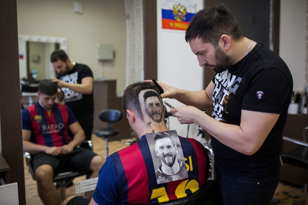 Serbian hairdresser Mario Hvala creates a hair tattoo showing the portrait of Argentinian football player Lionel Messi on the head of a football fan in Novi Sad, Serbia, on June 10, 2018. AFP / Vladimir Zivojinovic