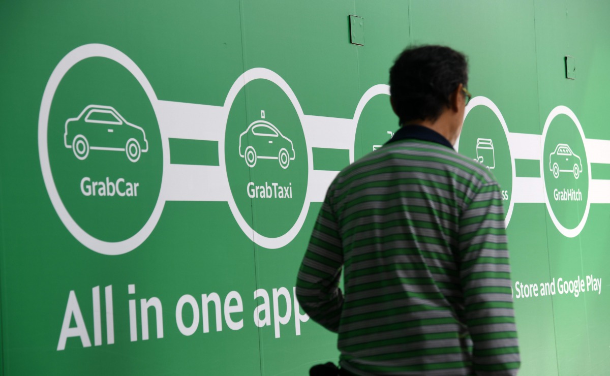 A man walk past the Grab transport office in Singapore on June 13, 2018. AFP / Roslan Rahman