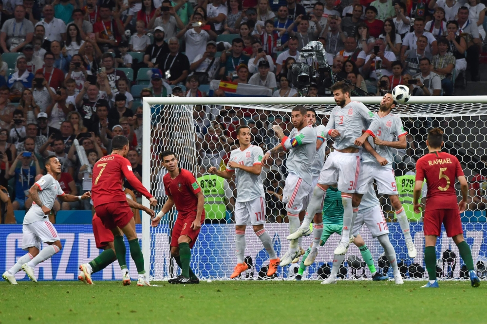 Portugal's forward Cristiano Ronaldo (2L) shoots to score his third goal during the Russia 2018 World Cup Group B football match between Portugal and Spain at the Fisht Stadium in Sochi on June 15, 2018. (AFP / Nelson Almeida)