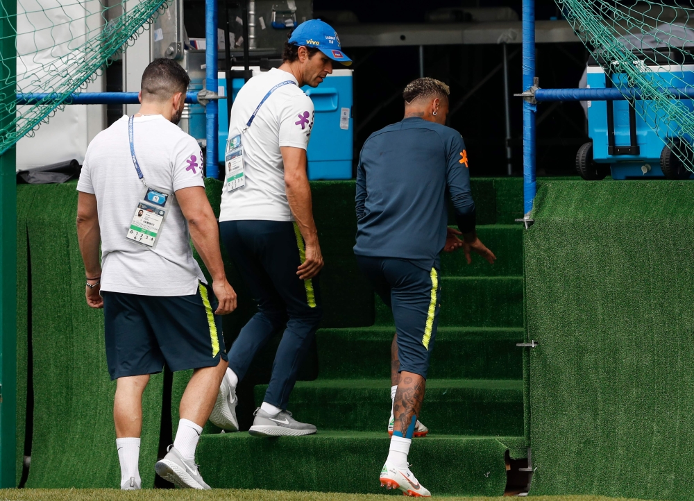 Brazil's forward Neymar (R) leaves the practice with team physio Bruno Mazziotti (L) and team Doctor Rodrigo Lasmar (C) during a training session of Brazil national football team at Yug Sport Stadium, in Sochi, on June 19, 2018, ahead of the Russia 2018 W