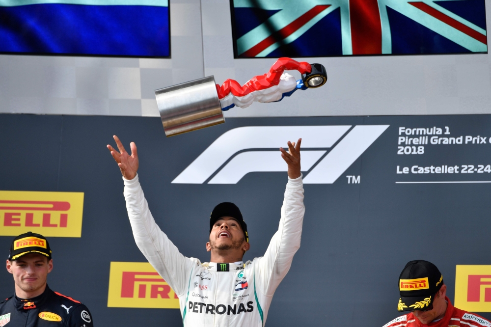 Winner Mercedes' British driver Lewis Hamilton (C) celebrates on the podium next to second placed Red Bull Racing's Dutch driver Max Verstappen (L) and third placed Ferrari's Finnish driver Kimi Raikkonen (R) after the Formula One Grand Prix de France at 