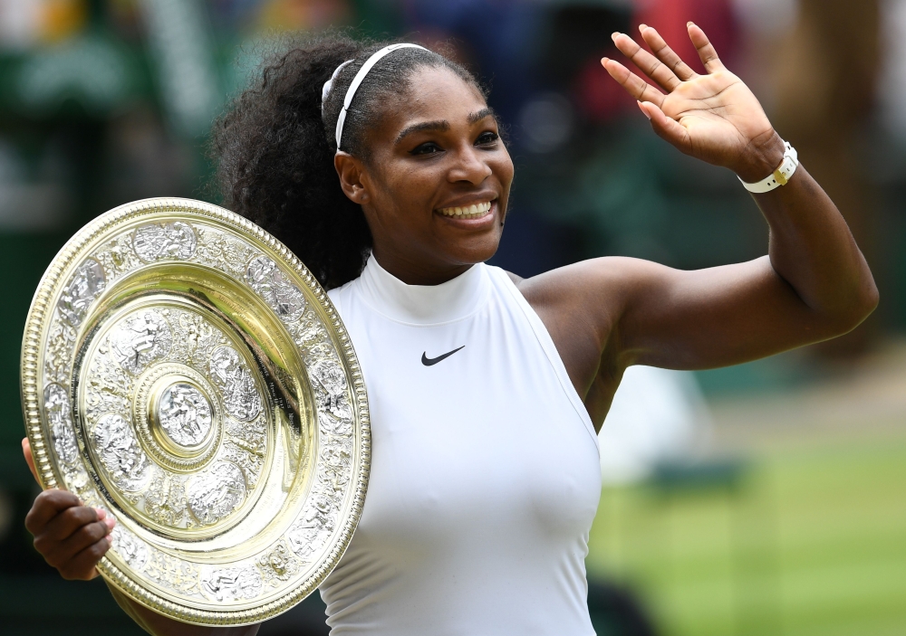 (FILES) In this file photo taken on July 09, 2016 US player Serena Williams poses with the winner's trophy, the Venus Rosewater Dish, after her women's singles final victory over Germany's Angelique Kerber on the thirteenth day of the 2016 Wimbledon Champ