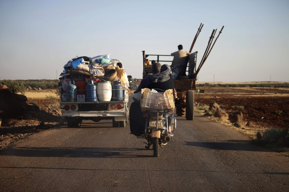 Civilians flee during airstrike by Syrian regime forces in the east of the southern Syrian province of Daraa on June 24, 2018.  AFP / Mohamad ABAZEED
