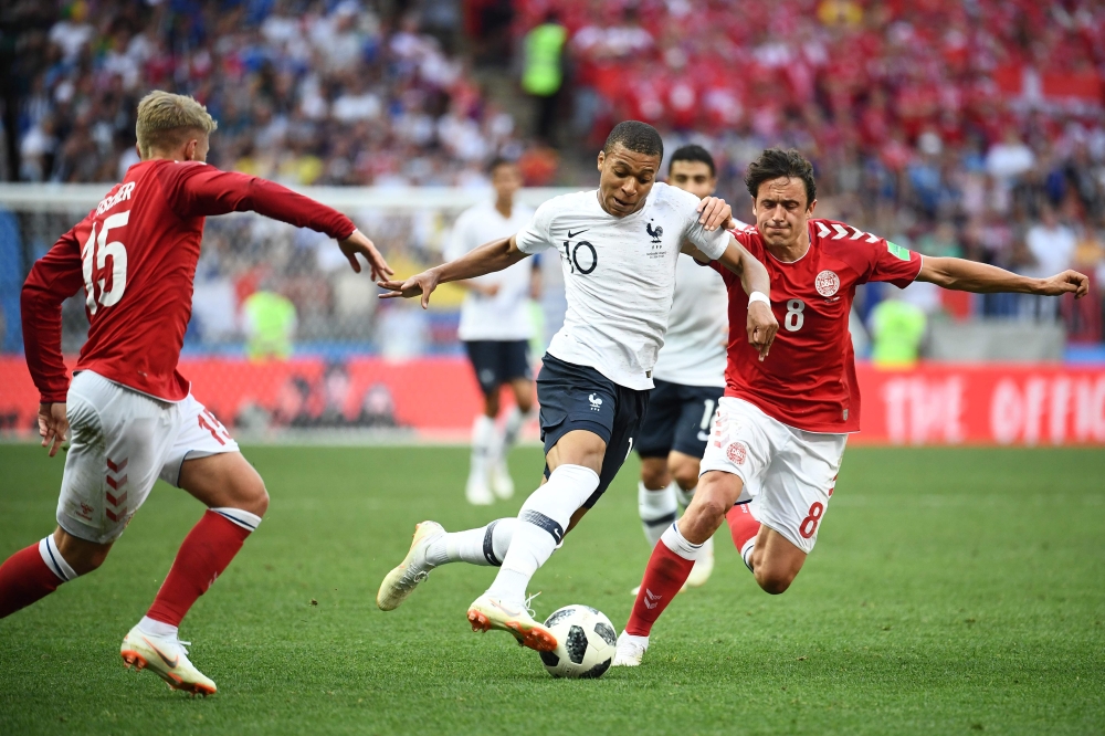 France's forward Kylian Mbappe (C) vies with Denmark's midfielder Thomas Delaney (R) during the Russia 2018 World Cup Group C football match between Denmark and France at the Luzhniki Stadium in Moscow on June 26, 2018. / AFP / FRANCK FIFE