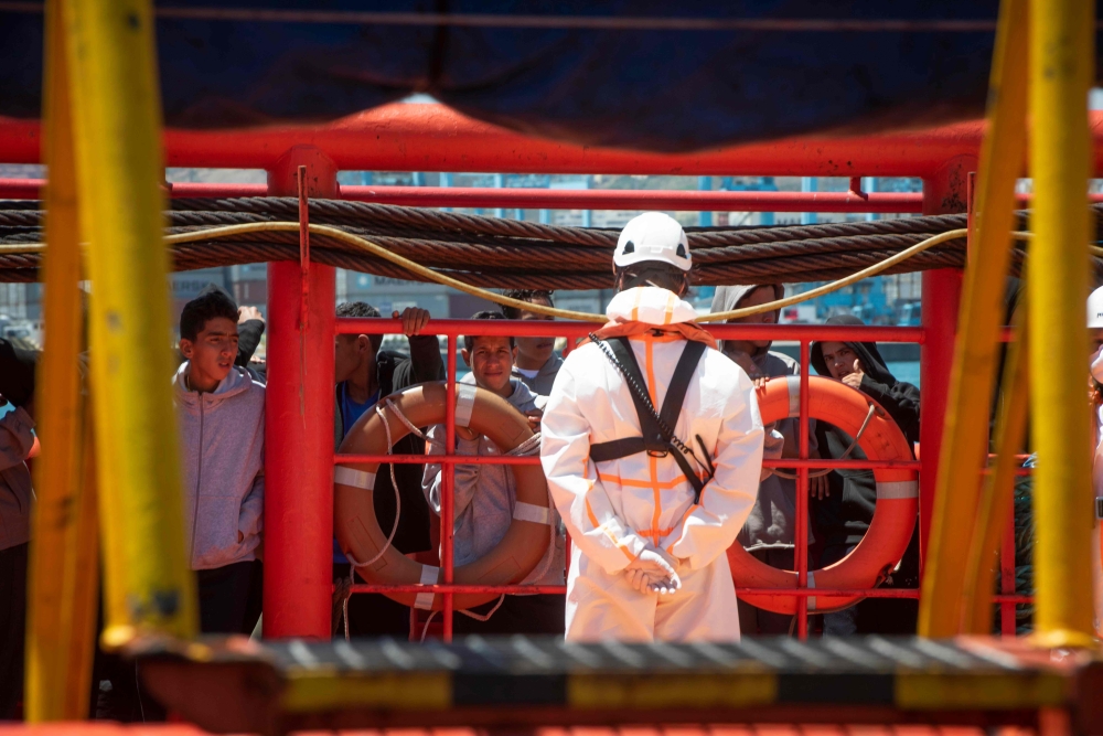 Young migrants wait on board the 