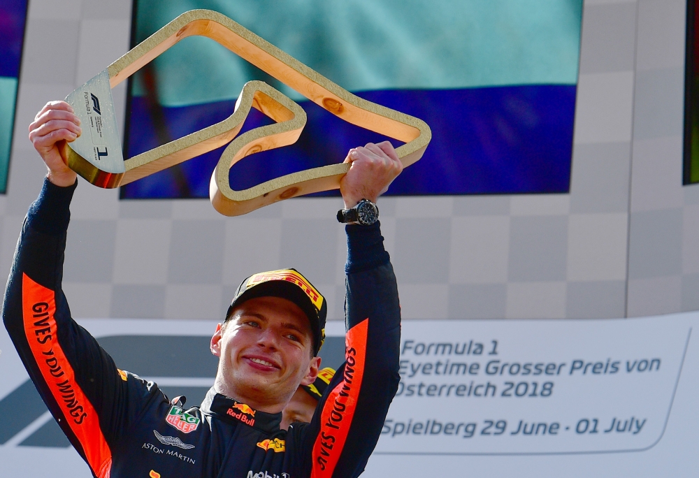 Winner Red Bull's Dutch driver Max Verstappen celebrates on the podium with the trophy after winning the Austrian Formula One Grand Prix in Spielberg, central Austria, on July 1, 2018. / AFP / ANDREJ ISAKOVIC