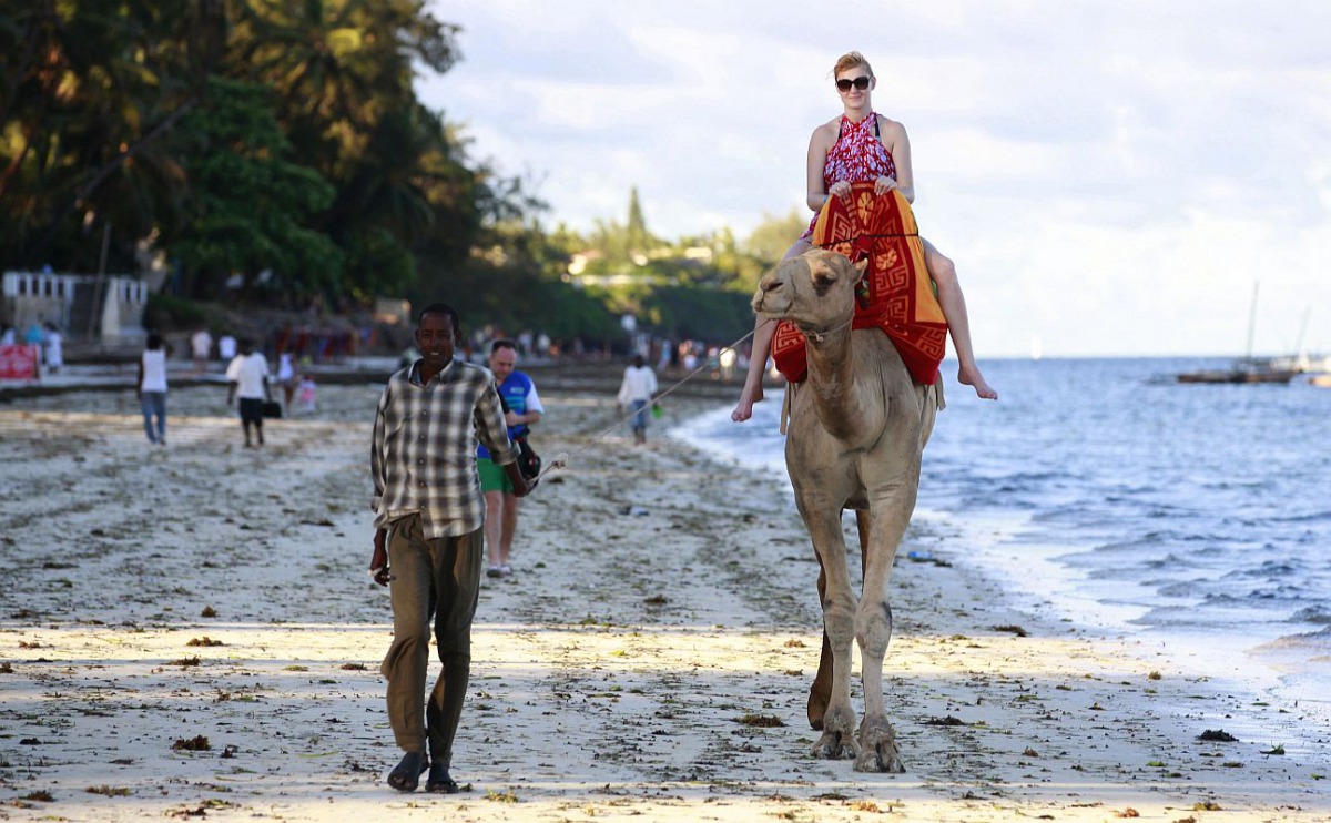 A tourist rides on camel back at the Jomo Kenyatta public beach in coastal city of Mombasa, Kenya March 24, 2013. Reuters/Joseph Okanga