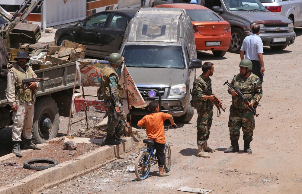 A Syrian child rides his bike after Syrian government forces recently recaptured the village of Ghariyah ash Sharqiyah from the rebels, in the province of Deraa, on July 4, 2018. (AFP / Youssef KARWASHAN)