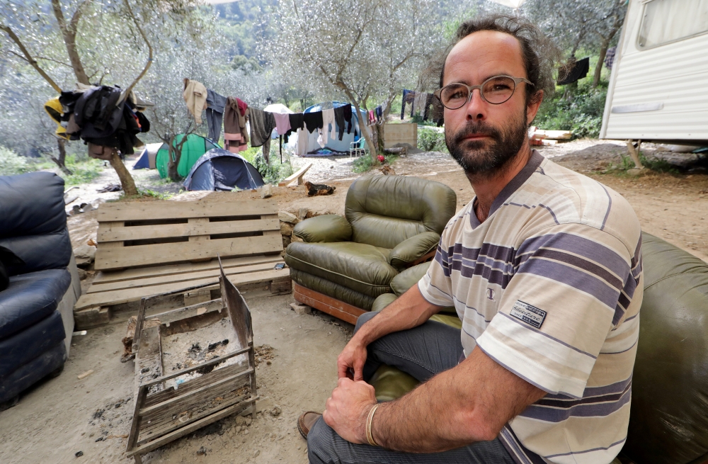 Cedric Herrou, a French farmer and volunteer assisting migrants to cross the French-Italian border to avoid police controls, poses as he sits in a couch near tents for migrants pitched at his land in Breil-sur-Roya, France, April 11, 2017.  Reuters/Eric G