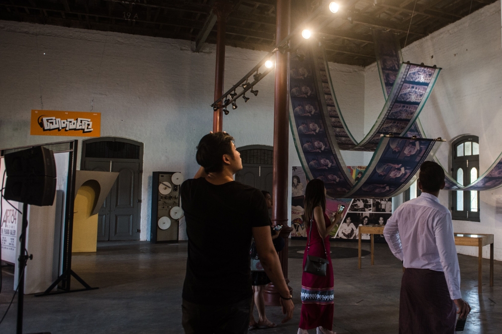 This picture taken on April 12, 2018 shows visitors view vintage movie materials displayed at the Myanmar film heritage exhibition at the historic Secretariat Building in Yangon.  AFP / Phyo Hein Kyaw