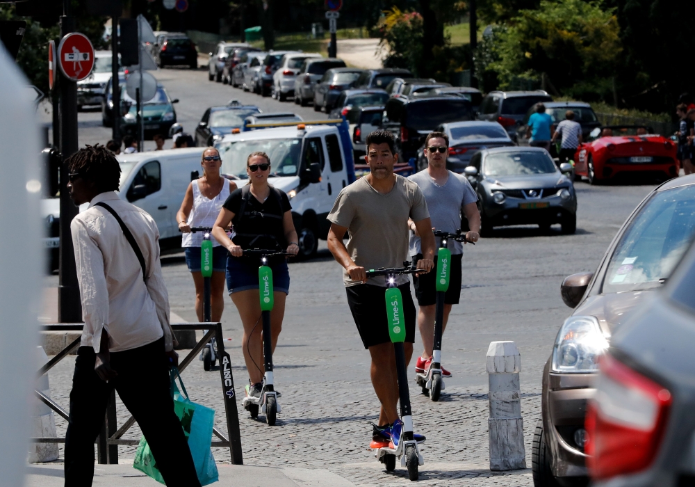 People use Electric scooters of the US company Lime in Paris on July 9, 2018. AFP / Francois Guillot

