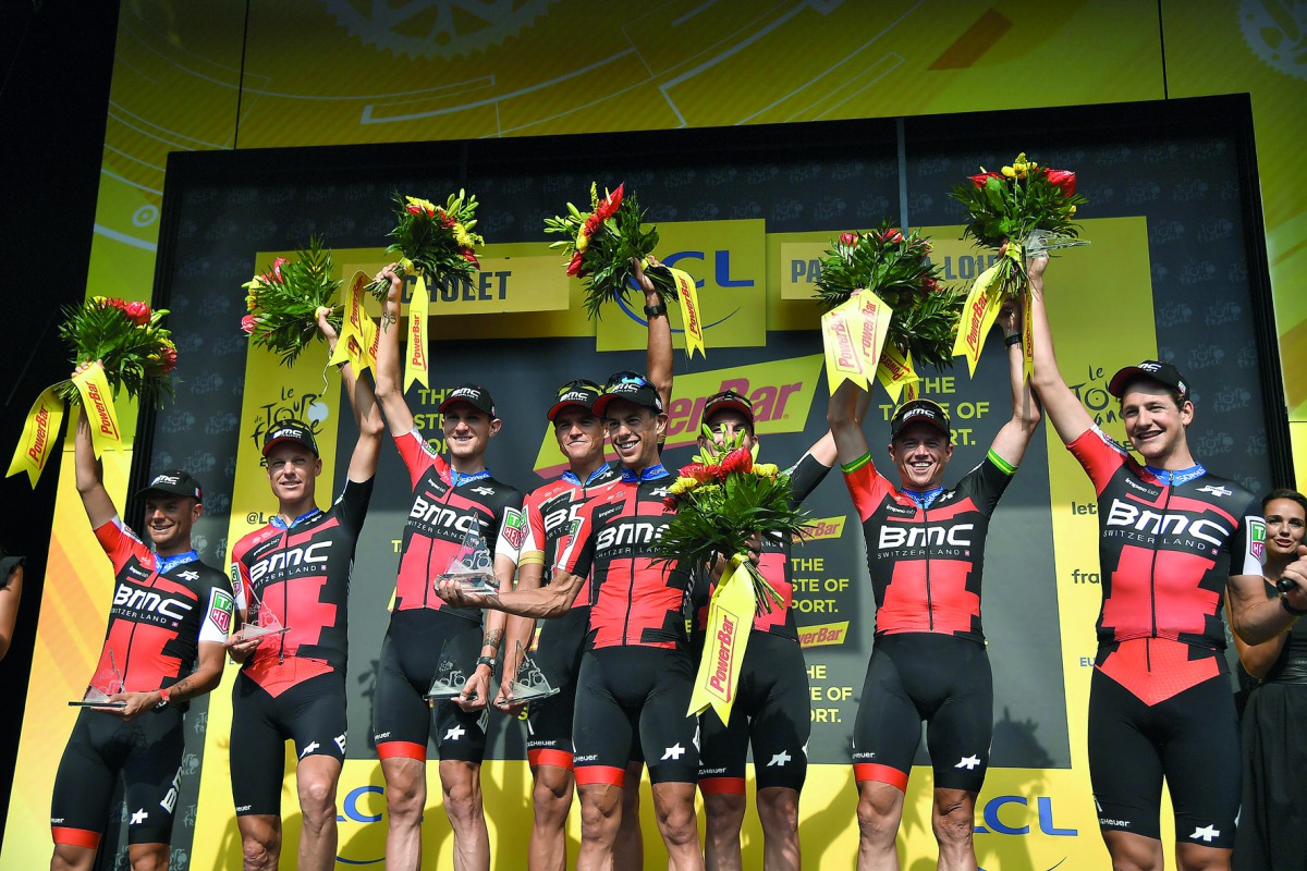 Australia's Richie Porte (C) and his teammates of USA's BMC Racing cycling team celebrate on the podium after winning the third stage of the 105th edition of the Tour de France cycling race, a 35.5 km team time-trial around Cholet, western France, on July