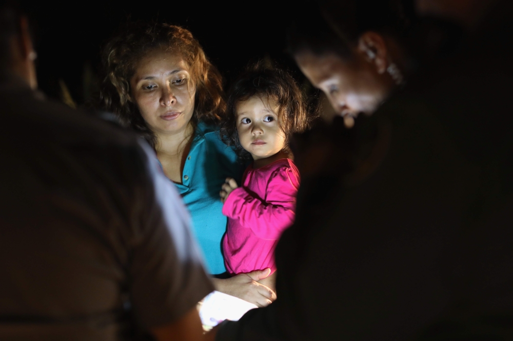 Central American asylum seekers, including a Honduran girl, 2, and her mother, near the US-Mexico border in McAllen, Texas on June 12, 2018. AFP / Getty Images North America / John Moore