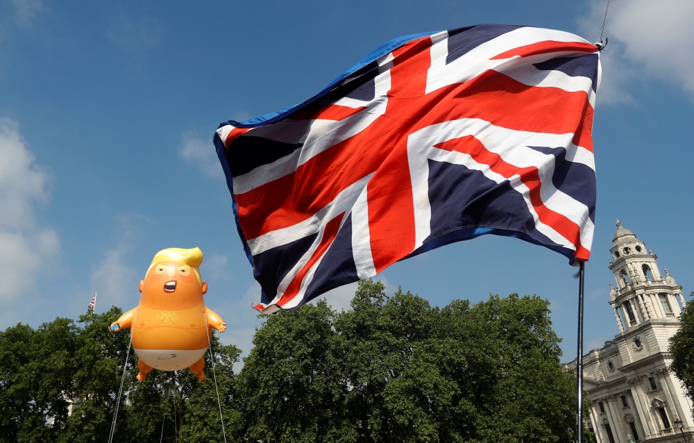 Demonstrators float a blimp portraying US President Donald Trump, next to a Union Flag above Parliament Square, during the visit by Trump and First Lady Melania Trump in London, Britain July 13, 2018. REUTERS/Peter Nicholls