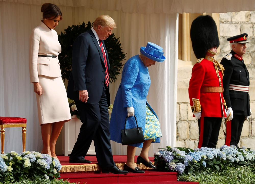 The First Lady Melania Trump waits as U.S. President Donald Trump and Britain's Queen Elizabeth walk across the courtyard to inspect the Coldstream Guards during a visit to Windsor Castle in Windsor, Britain, July 13, 2018. Reuters/Kevin Lamarque

