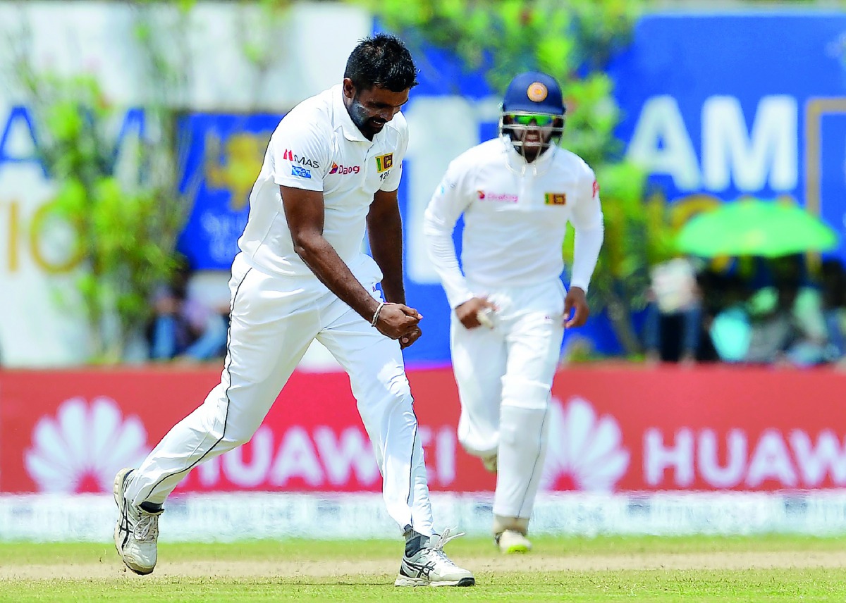 Sri Lanka's Dilruwan Perera (L) celebrates after dismissing South Africa's Quinton de Kock (not pictured) during the second day of the opening Test match between Sri Lanka and South Africa at the Galle International Cricket Stadium in Galle on July 13, 20