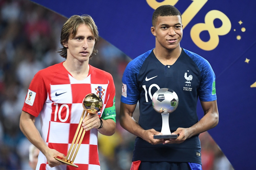 France's forward Kylian Mbappe (R) poses with the FIFA Young Player award beside Croatia's midfielder Luka Modric holding the adidas Golden Ball prize during the trophy ceremony at the end of the Russia 2018 World Cup final football match between France a