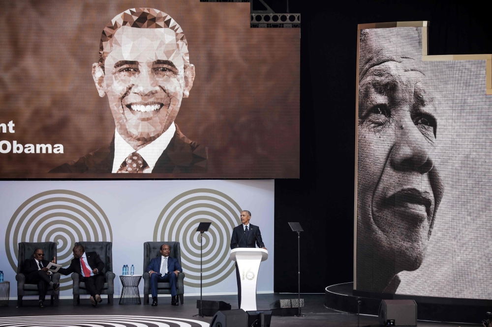 Barack Obama (R) speaks next to the Chancellor of the University of Johannesburg, Professor Njabulo Ndebele (L), South African President Cyril Ramaphosa (2ndL) and Patrice Motsepe, businessman and founder of the Motsepe Foundation, during the 2018 Nelson 