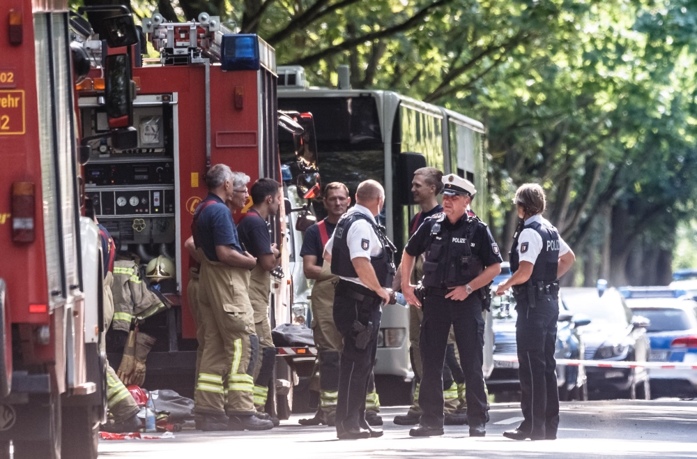 Policemen stand near a public service bus in Kuecknitz near Luebeck northern Germany, after several people were injured in the bus in an assault by a man wielding a knife on July 20, 2018. (AFP / dpa / Markus Scholz)