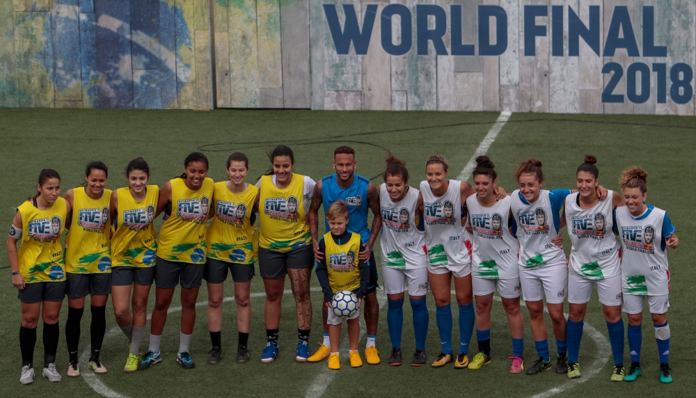 Brazilian football star Neymar (C) poses with his son Davi Lucca and female players before a game during a five-a-side football tournament for his charity Neymar Junior Project Institute, in Praia Grande, Sao Paulo, Brazil, on July 21, 2018. / AFP / Migue