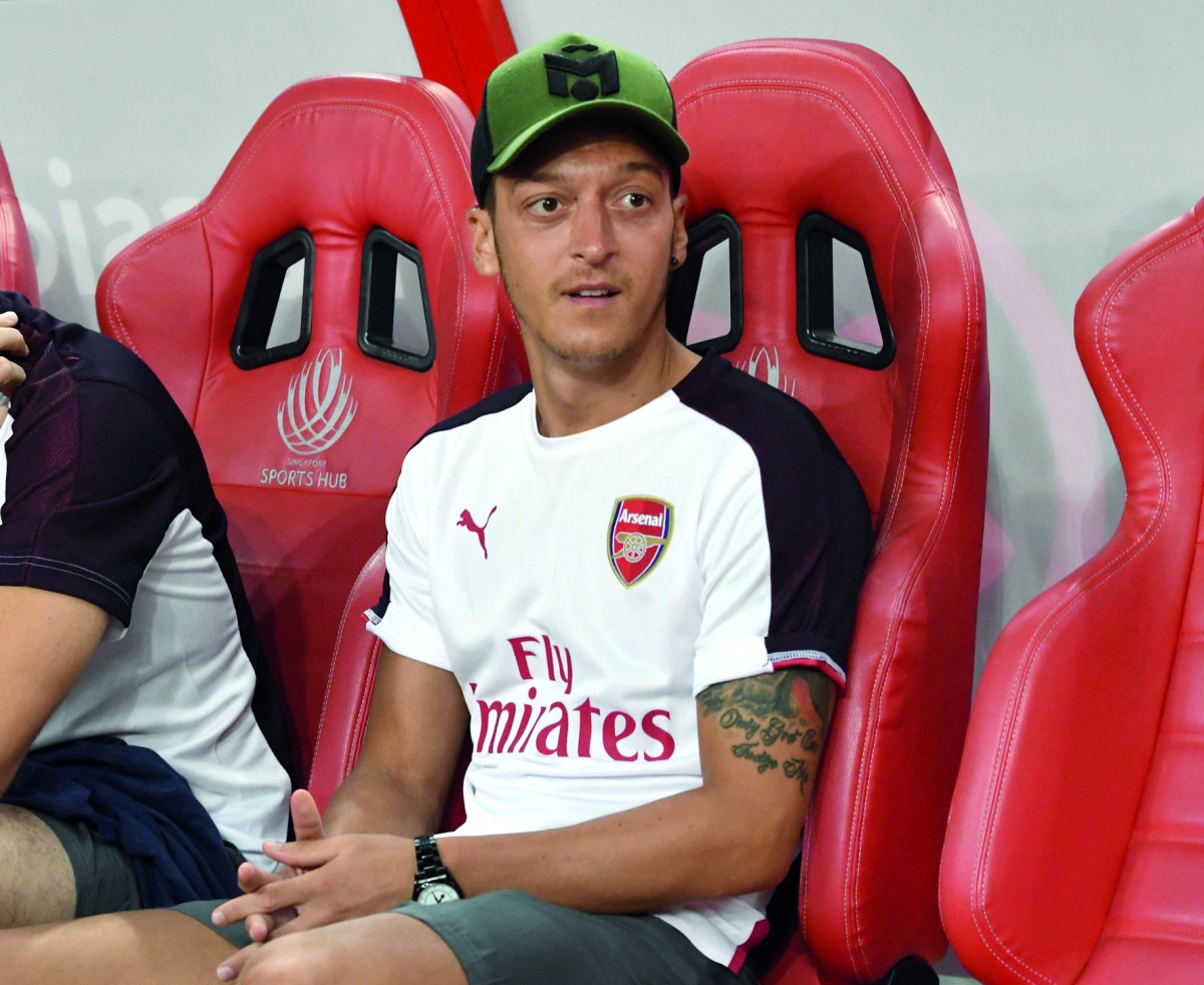 Mesut Ozil of Arsenal sits at the players bench during a match against Atletico Madrid at the International Champions Cup match in Singapore on July 26, 2018. AFP / Roslan Rahman