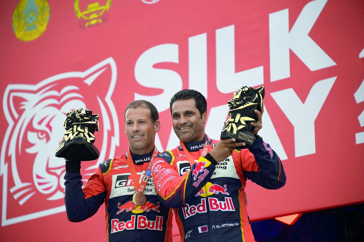 Overdrive Racing’s Qatari driver Nasser Saleh Al Attiyah (right) and French co-drive Mathieu Baumel celebrate with their trophies after finishing second in the Silk Way Rally 2018, at the Red Square in Moscow, Russia yesterday.