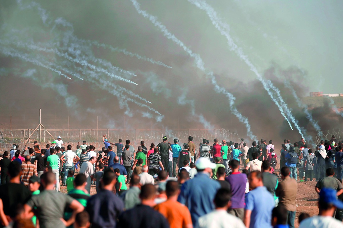 Palestinian protesters gather as tear gas canisters are launched by Israeli forces during a demonstration along the border between Israel and the Gaza strip, east of Gaza city on July 27, 2018. AFP / Mahmud Hams

