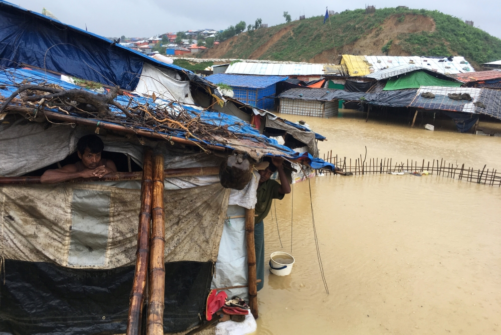 Abdul Hakim (L), a Rohingya refugee man looks on as his shelter gets flooded after heavy rain in Cox’s Bazar, Bangladesh July 25, 2018. Reuters/Clare Baldwin