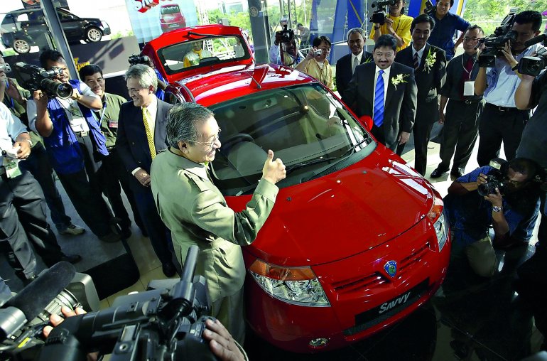 In this file photo Mahathir Mohamad gives a thumbs-up sign during the launch of the Proton Savvy, the national carmaker's new model in Kuala Lumpur on June 8, 2005. AFP / Tengku Bahar / File photo
