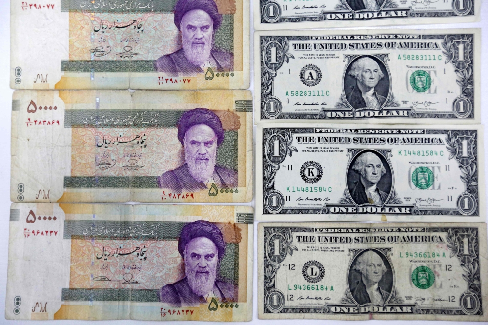 Iran rial banknotes next to US one-Dollar bills at a currency exchange office in Tehran, on April 10, 2018 (AFP / Atta Kenare) 