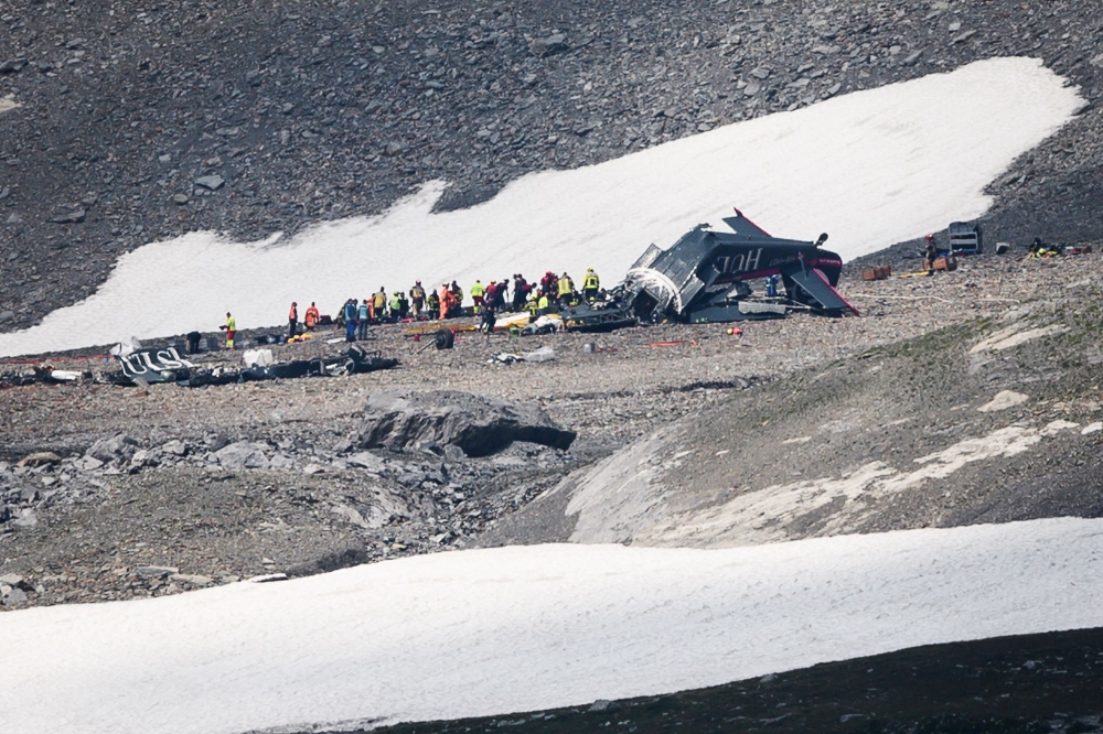 Accident investigators and rescue personnel work at the wreckage of a Junkers JU52 aircraft in Flims on August 5, 2018, after it crashed into Piz Segnas, a 3,000-metre (10,000-foot) peak in eastern Switzerland on August 4. AFP / Fabrice Coffrini
 