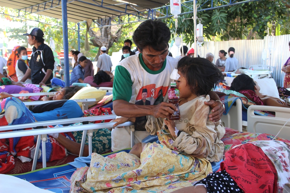 Injured victims rest at a makeshift hospital in Pemenang, North Lombok on August 6, 2018, the day after a 6.9 magnitude earthquake struck the area.  AFP / Pikong 