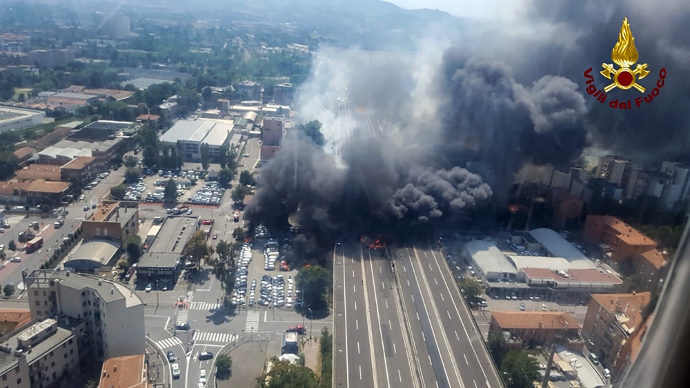 This handout picture taken from an helicopter and released by the Vigili del Fuoco, the Italian firement, on August 6, 2018, shows black smoke rising in the sky after a tanker exploded on the motorway close to the airport, in Bologna. AFP / HO/ Vigili Dle