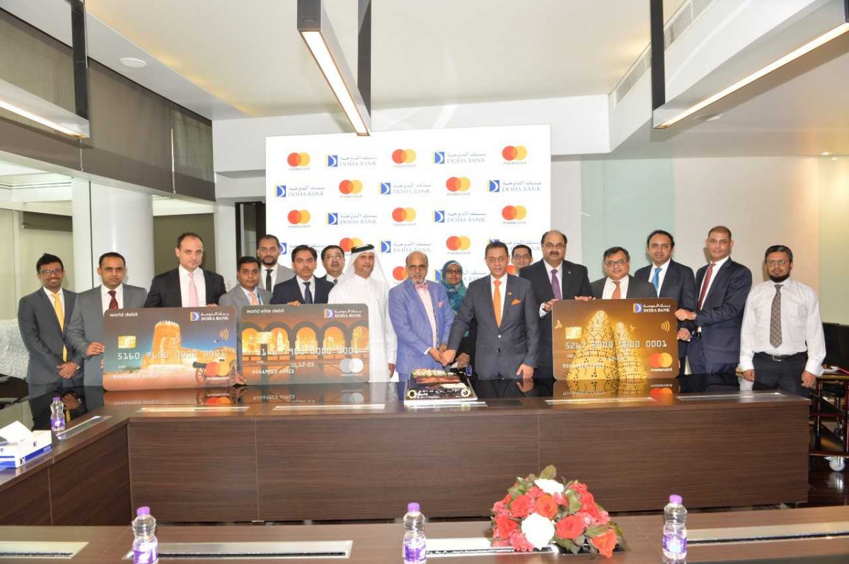 Dr Seetharaman (centre), Group CEO, Doha Bank; Khalid Elgibali (seventh right), Division President, Middle East and North Africa, at Mastercard, cut a cake to mark the launch of a suite of new debit card products with innovative value-added services for i
