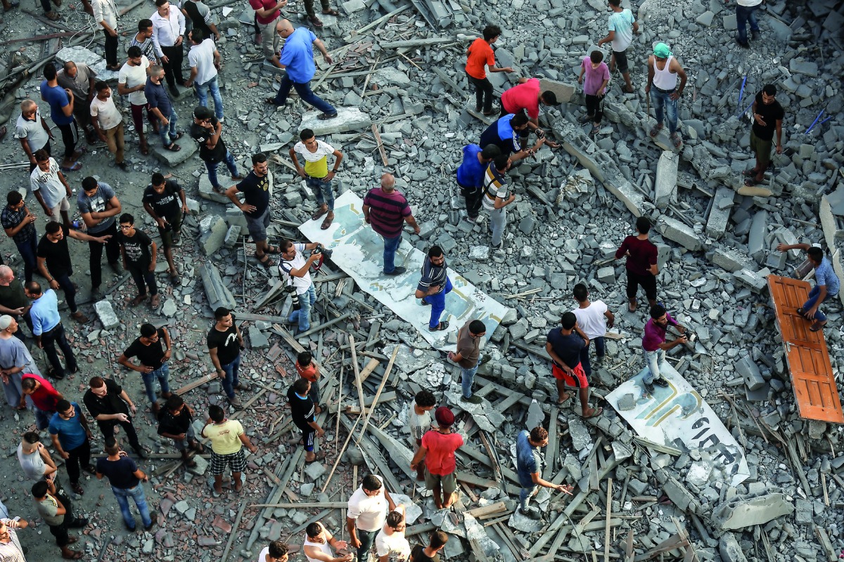 People inspect the debris of Said Al-Mashal Foundation for Arts and Culture building after Israeli forces conducted airstrikes with at least ten rockets targeted the cultural center, in western part of Gaza City, Gaza on August 09, 2018. (Ali Jadallah/Ana