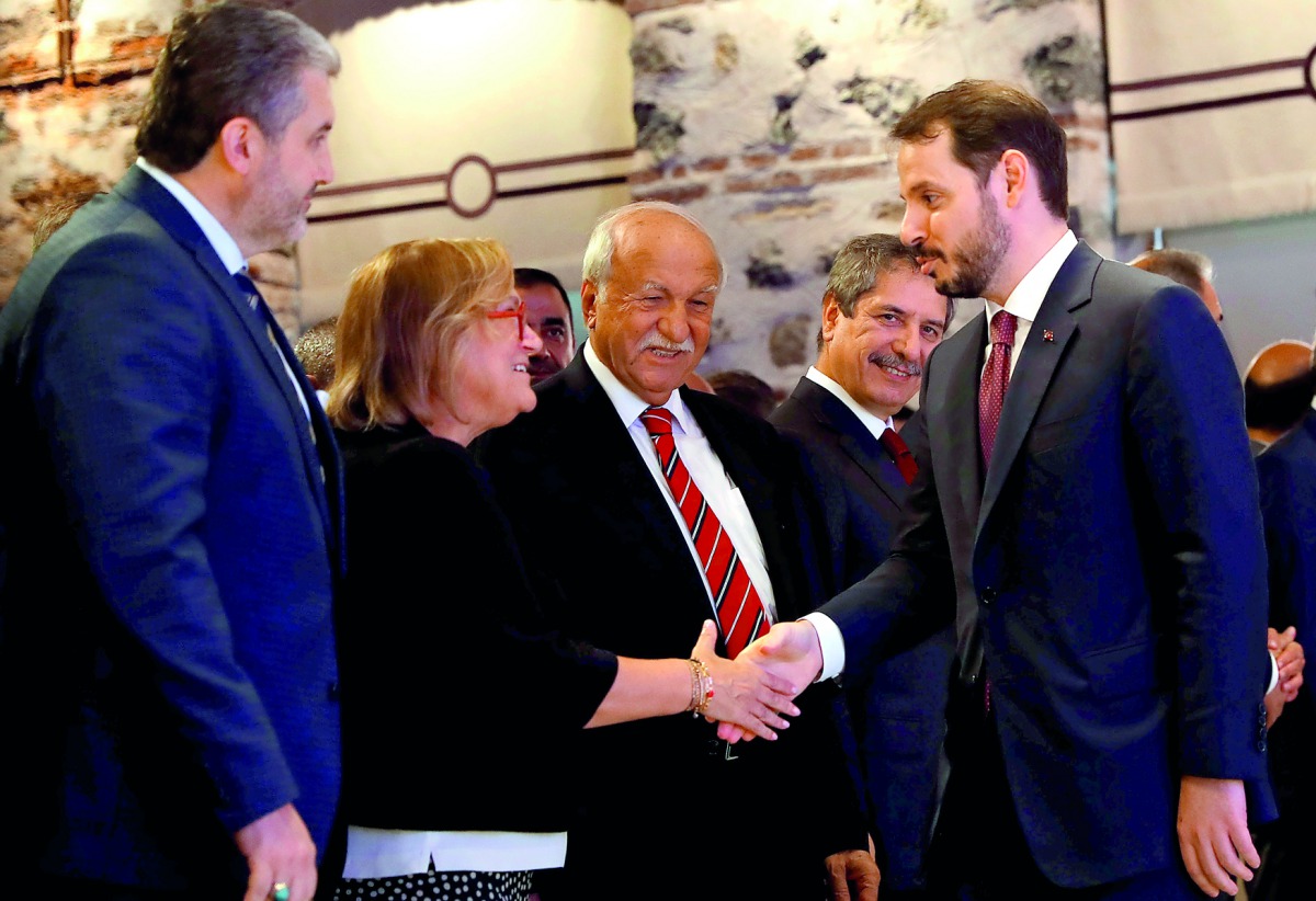 Turkish Treasury and Finance Minister Berat Albayrak shakes hands with Guler Sabanci, Sabanci Group Chairman of the Board, before a presentation to announce his economic policy in Istanbul, Turkey August 10, 2018. Reuters/Murad Sezer