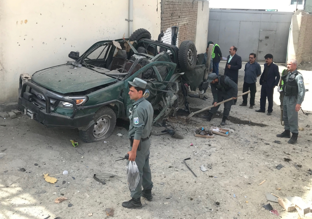 Afghan policemen inspect a damaged police vehicle after a suicide attack near the The Independent Election Commission (IEC) office in Kabul, Afghanistan August 13, 2018.REUTERS/Sayed Hassib