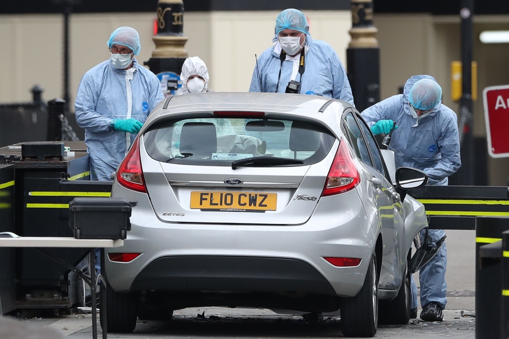 Police forensics officers work around a silver Ford Fiesta car that was driven into a barrier at the Houses of Parliament in central London on August 14, 2018.  AFP / Daniel Leal-Olivas 