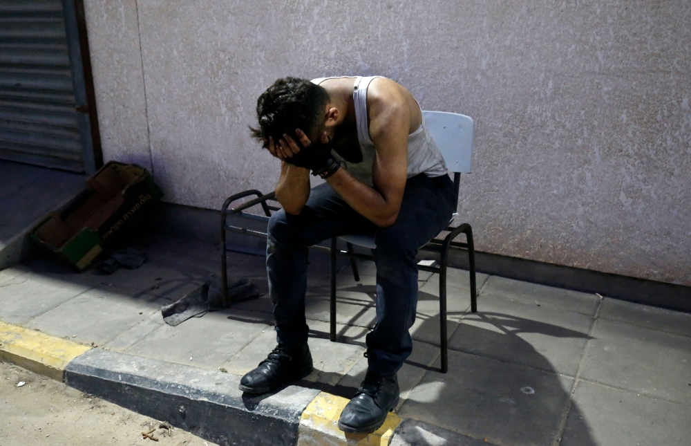 A friend of Sadi Moamer, 26, who was killed during demonstrations near Rafah, mourns outside of a hospital near Rafah on August 17, 2018.  AFP / Said Khatib 