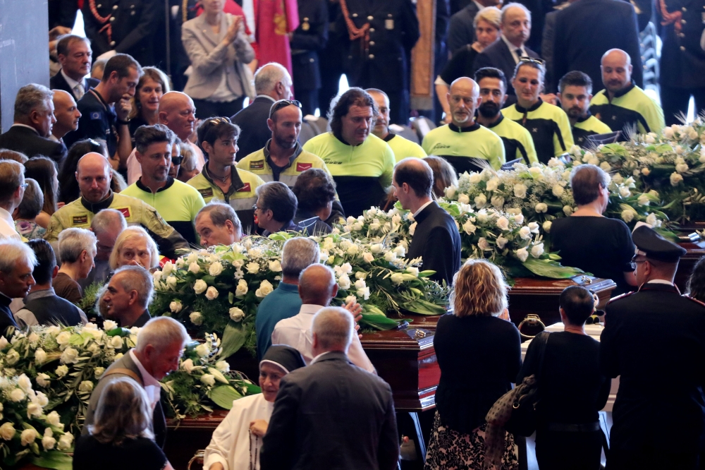 Firefighters arrive to pay their respects to the victims of the Morandi Bridge collapse, before the state funeral at the Genoa Trade Fair and Exhibition Centre in Genoa, Italy August 18, 2018. REUTERS/Stefano Rellandini 