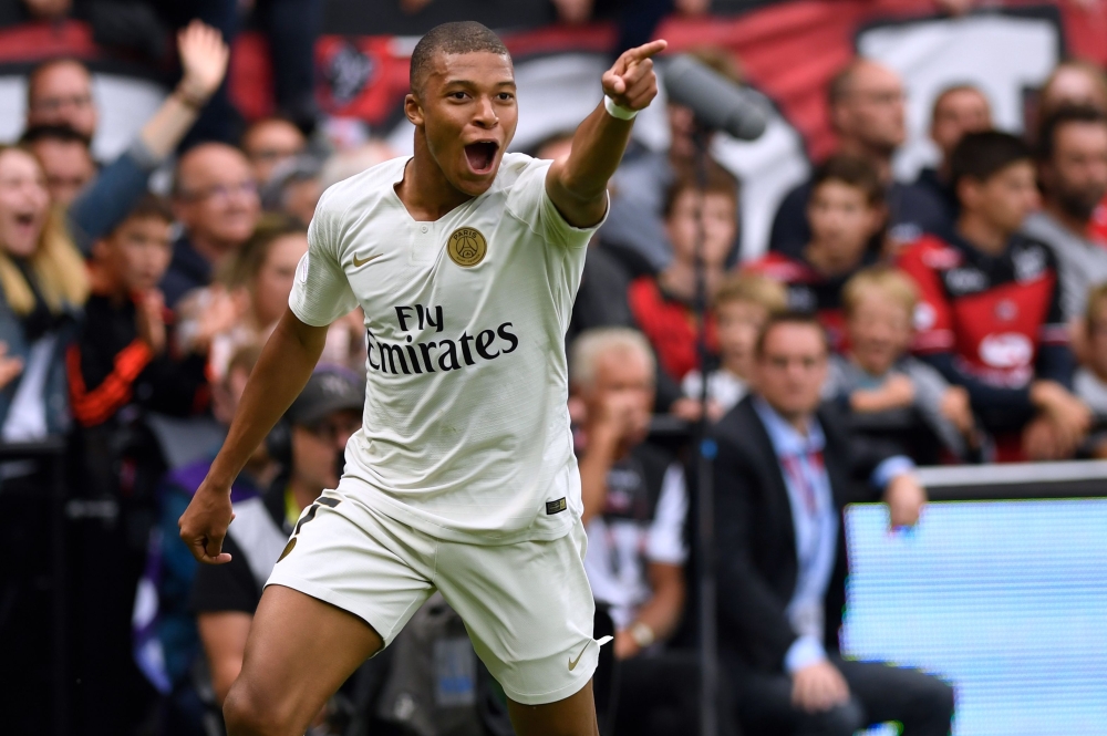 Paris Saint-Germain's French forward Kylian Mbappe celebrates after scoring their third goal during the French L1 football match between Guingamp and Paris Saint-Germain, at the Roudourou stadium in Guingamp on August 18, 2018. (AFP / FRED TANNEAU)