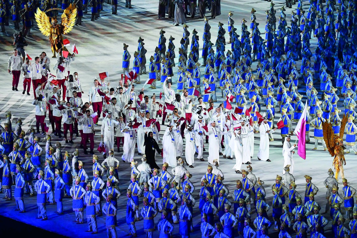 Squash star Abdulla Al Tamimi (right) carries the national flag as Qatari contingent parades during the opening ceremony of the 2018 Asian Games at the Gelora Bung Karno Stadium in Jakarta, Indonesia, yesterday.