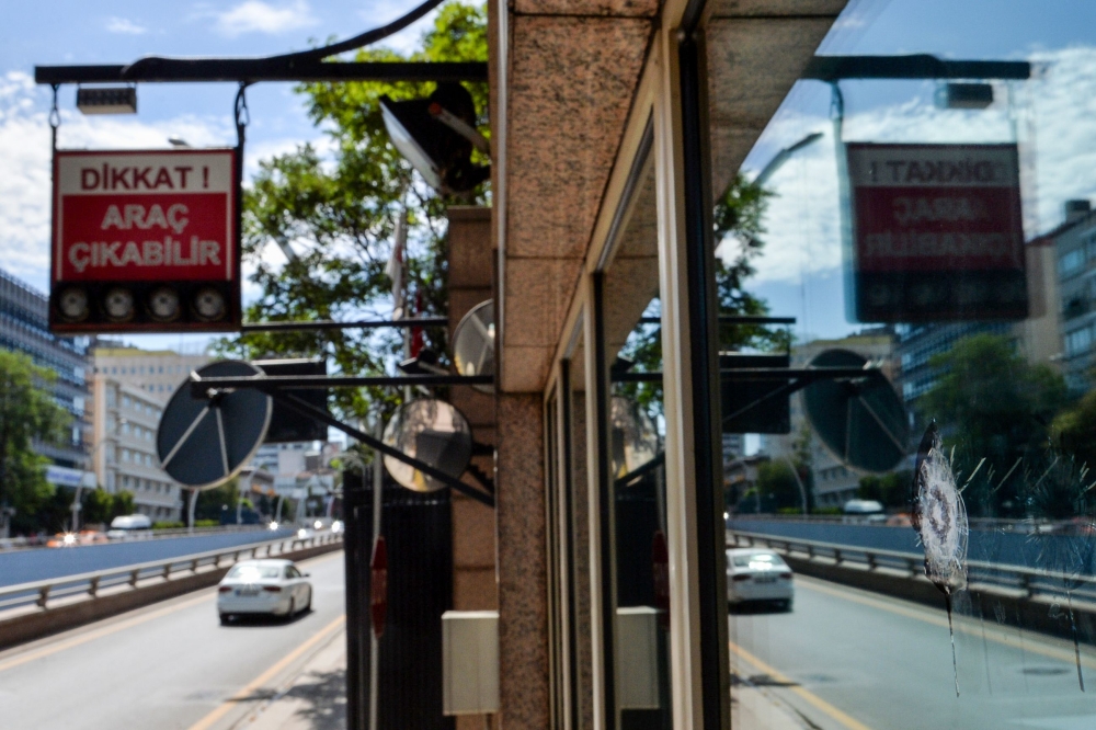  A car passes by a security booth with a bullet hole in a window, at the entrance of the US Embassy, in Ankara, on August 20, 2018. (AFP)